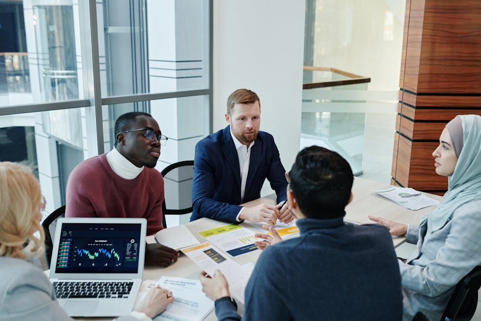 A diverse group of professionals engaged in an office meeting, discussing business strategies.